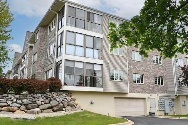 2142 Chateau Ct Unit 308-2, Grafton, WI 53024 - view of property featuring a garage, asphalt driveway, and cooling unit