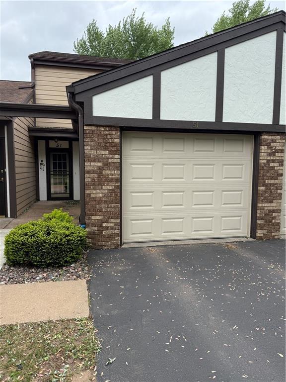 51 Stump Lake Rd, Chippewa Falls, WI 54729 - view of front of house with brick siding, driveway, and a garage