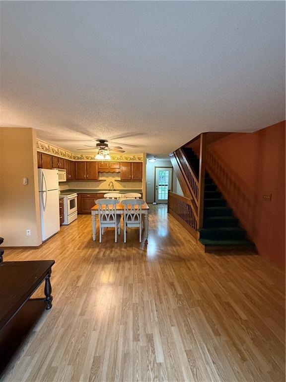 51 Stump Lake Rd, Chippewa Falls, WI 54729 - living area featuring stairs, light wood-type flooring, ceiling fan, and a textured ceiling