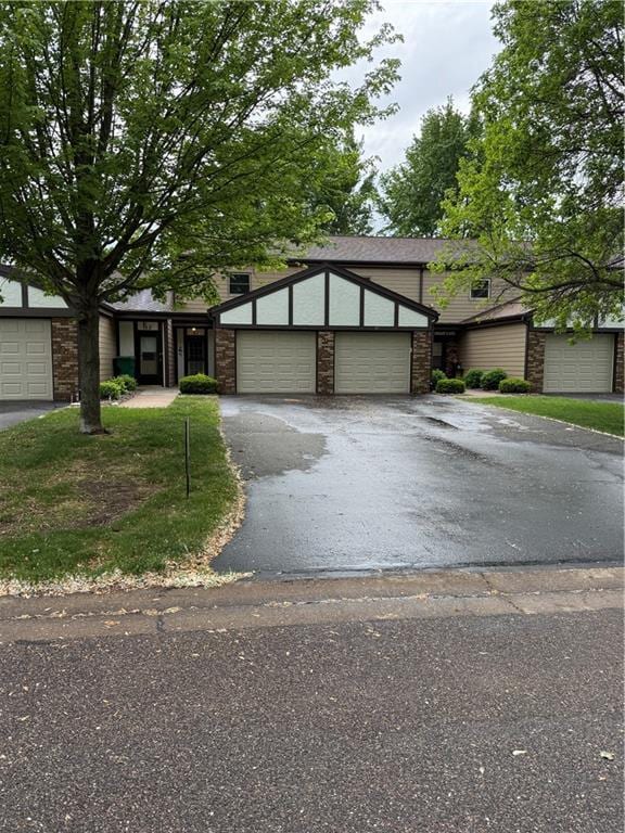 51 Stump Lake Rd, Chippewa Falls, WI 54729 - view of front of property with stone siding, asphalt driveway, and a garage