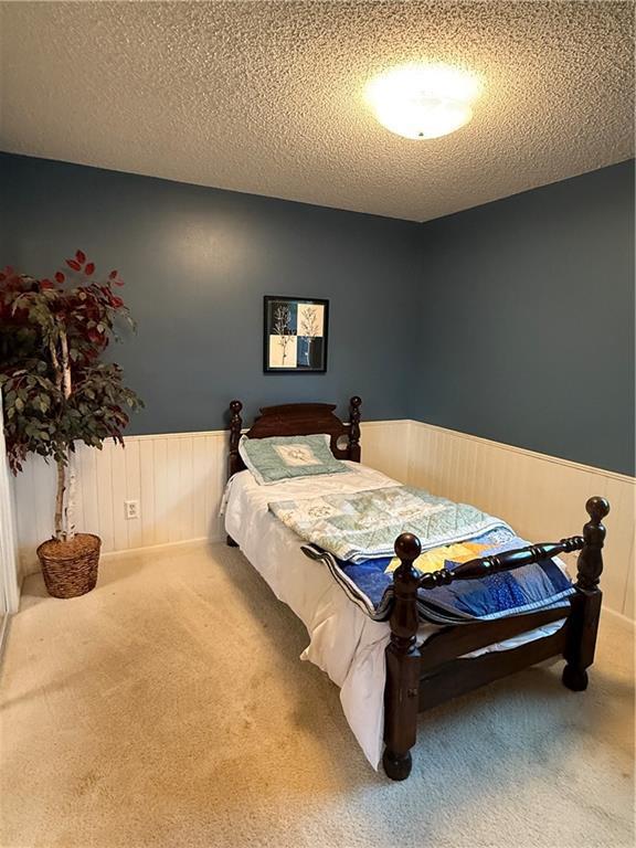51 Stump Lake Rd, Chippewa Falls, WI 54729 - bedroom with a wainscoted wall, carpet flooring, and a textured ceiling