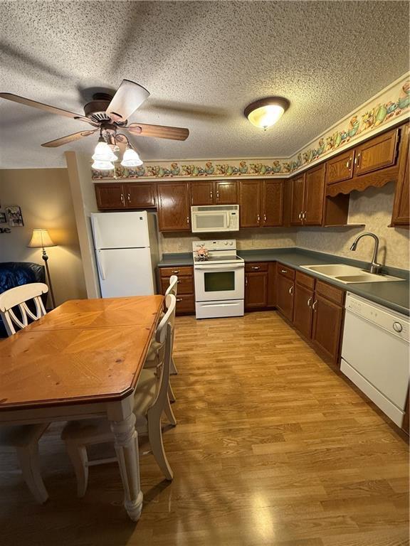 51 Stump Lake Rd, Chippewa Falls, WI 54729 - kitchen featuring white appliances, a sink, ceiling fan, light wood finished floors, and dark countertops