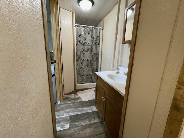 4546 Gold Leaf Ln, Ojibwa, WI 54862 - bathroom featuring wood finished floors, a stall shower, vanity, and a textured wall
