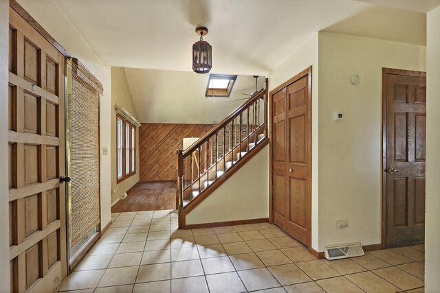 N7094 Evergreen Ln, Elkhorn, WI 53121 - entryway featuring stairs, light tile patterned floors, healthy amount of natural light, baseboards, and wood walls