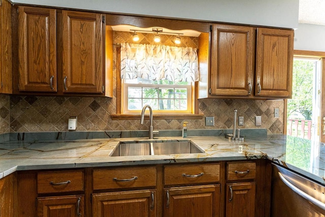 715 Farmer Ave, Tomah, WI 54660 - kitchen with a sink, stainless steel dishwasher, brown cabinets, and decorative backsplash