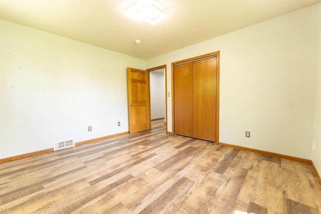 715 Farmer Ave, Tomah, WI 54660 - unfurnished bedroom featuring baseboards, light wood-style flooring, and a closet