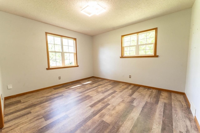 715 Farmer Ave, Tomah, WI 54660 - spare room featuring wood finished floors, a textured ceiling, and baseboards