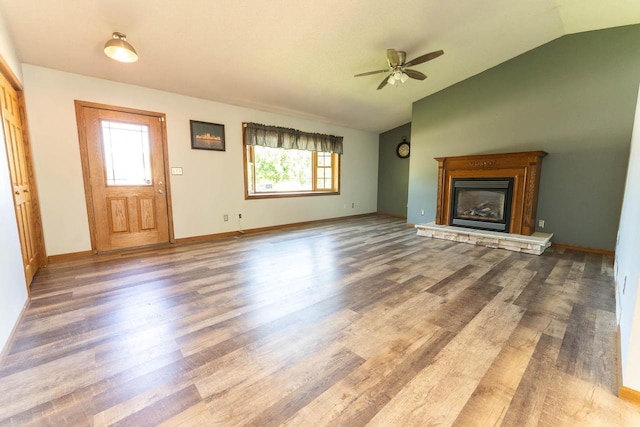 715 Farmer Ave, Tomah, WI 54660 - unfurnished living room with lofted ceiling, ceiling fan, wood finished floors, a glass covered fireplace, and baseboards