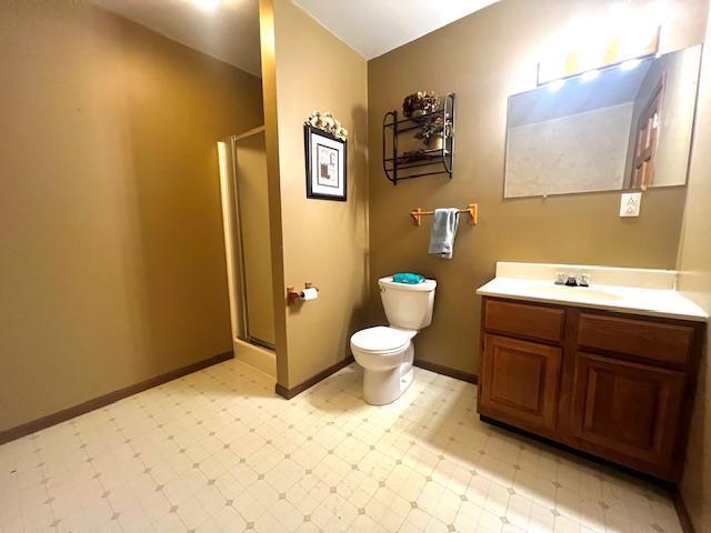 715 Farmer Ave, Tomah, WI 54660 - bathroom with tile patterned floors, a stall shower, vanity, toilet, and baseboards