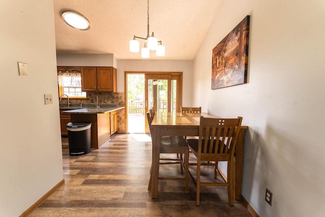 715 Farmer Ave, Tomah, WI 54660 - dining area with healthy amount of natural light, dark wood finished floors, a chandelier, baseboards, and a textured ceiling