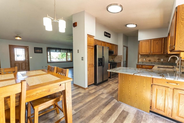 715 Farmer Ave, Tomah, WI 54660 - kitchen with a sink, appliances with stainless steel finishes, light wood-type flooring, a peninsula, and decorative backsplash
