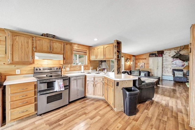 W6576 20th Dr, Wautoma, WI 54982 - kitchen featuring appliances with stainless steel finishes, extractor fan, a peninsula, light wood-style flooring, and vaulted ceiling