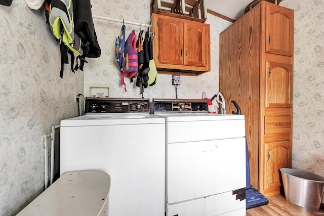 W6576 20th Dr, Wautoma, WI 54982 - laundry room featuring washing machine and clothes dryer, wallpapered walls, cabinet space, and light wood-style floors