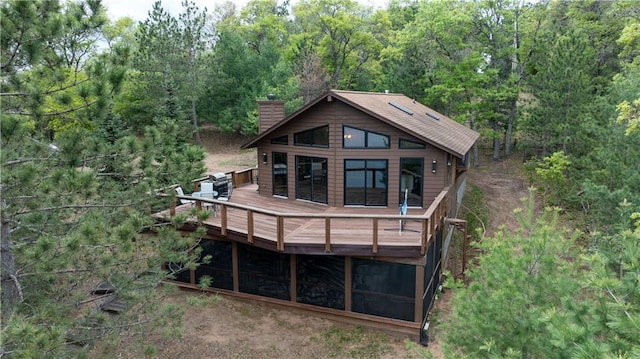 W7607 Whitetail Dr, Minong, WI 54859 - back of property with a chimney, a deck, and a forest view