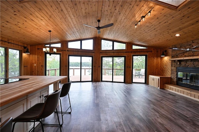 W7607 Whitetail Dr, Minong, WI 54859 - dining room with wooden walls, lofted ceiling, a stone fireplace, dark wood-style flooring, and wooden ceiling