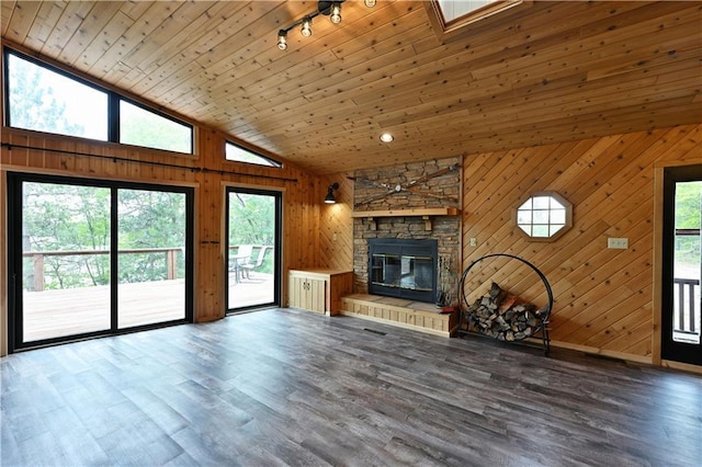W7607 Whitetail Dr, Minong, WI 54859 - unfurnished living room with plenty of natural light, wooden walls, rail lighting, wood finished floors, and a fireplace