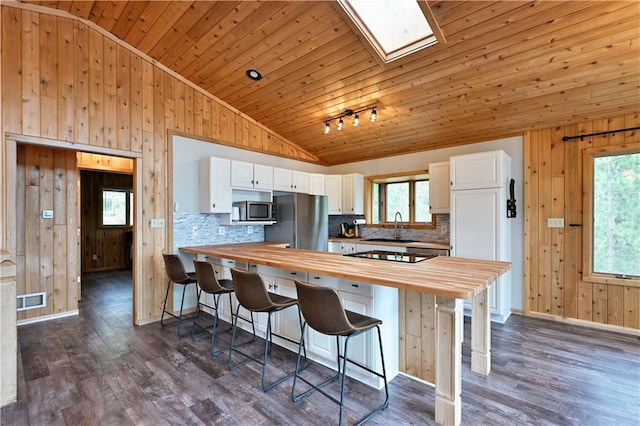 W7607 Whitetail Dr, Minong, WI 54859 - kitchen featuring wooden counters, vaulted ceiling, appliances with stainless steel finishes, wood walls, and a sink