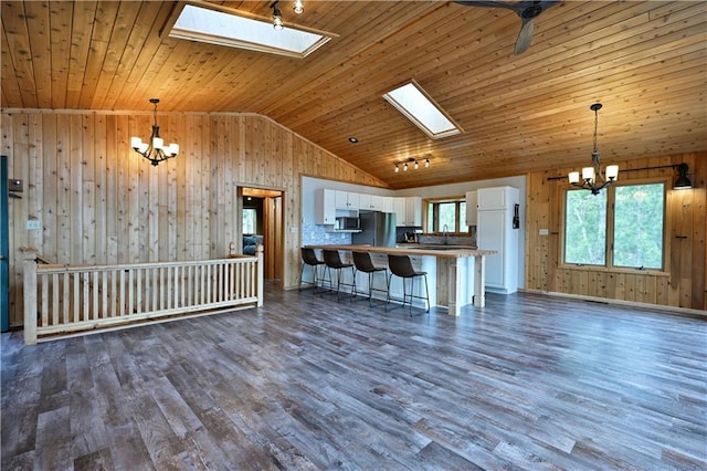 W7607 Whitetail Dr, Minong, WI 54859 - kitchen with a chandelier, wood walls, stainless steel microwave, a skylight, and wooden ceiling