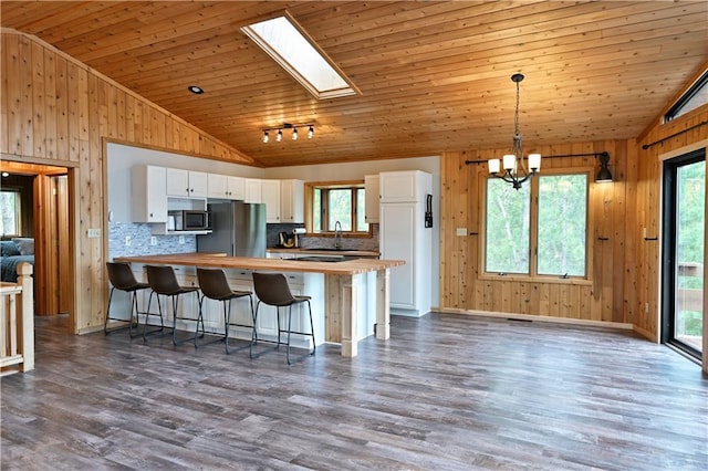 W7607 Whitetail Dr, Minong, WI 54859 - kitchen featuring lofted ceiling, stainless steel appliances, butcher block counters, wood walls, and healthy amount of natural light