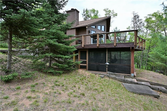W7607 Whitetail Dr, Minong, WI 54859 - back of property featuring a sunroom, a chimney, a balcony, and a deck