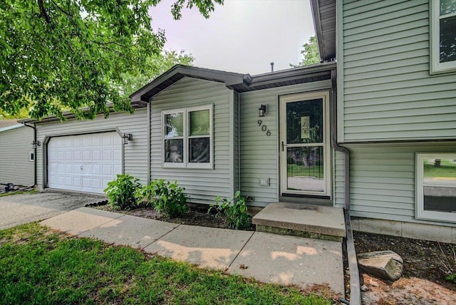 906 Spahn Dr, Waunakee, WI 53597 - view of exterior entry featuring an attached garage and asphalt driveway
