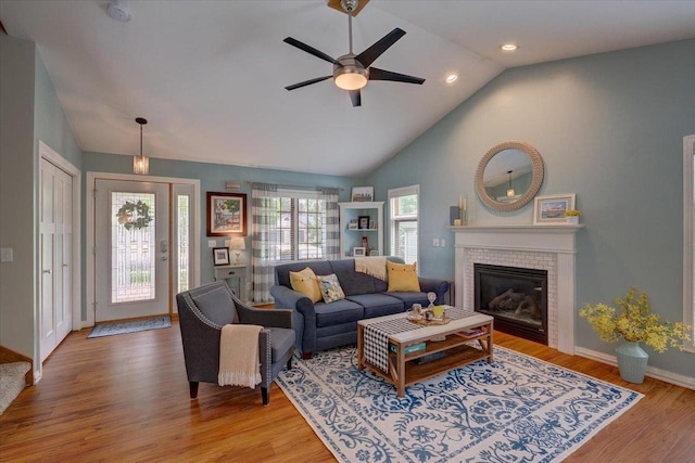 2330 Mica Rd, Madison, WI 53719 - living area featuring a brick fireplace, a ceiling fan, light wood-style flooring, baseboards, and high vaulted ceiling
