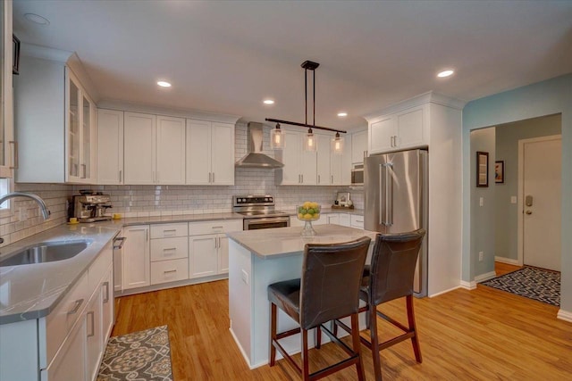 2330 Mica Rd, Madison, WI 53719 - kitchen featuring wall chimney exhaust hood, appliances with stainless steel finishes, a sink, white cabinetry, and decorative backsplash