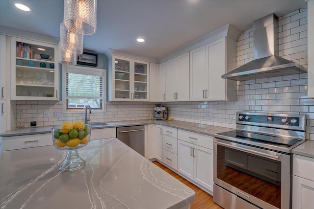 2330 Mica Rd, Madison, WI 53719 - kitchen featuring stainless steel appliances, wall chimney range hood, a sink, tasteful backsplash, and white cabinets