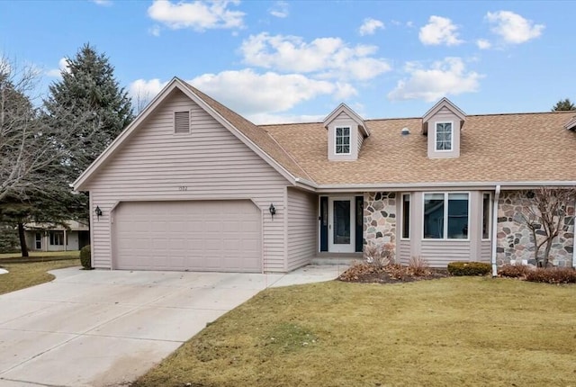 1502 Ridgewood Dr Unit D-7, West Bend, WI 53095 - view of front of house featuring roof with shingles, stone siding, concrete driveway, a front yard, and a garage