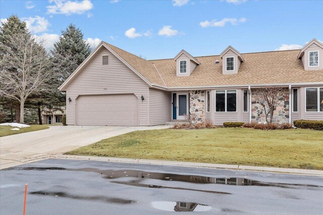 1502 Ridgewood Dr Unit D-7, West Bend, WI 53095 - view of front of home with stone siding, a front lawn, an attached garage, and concrete driveway
