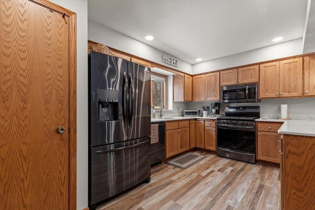 1502 Ridgewood Dr Unit D-7, West Bend, WI 53095 - kitchen with fridge with ice dispenser, gas range oven, stainless steel microwave, dishwasher, and light wood-style flooring