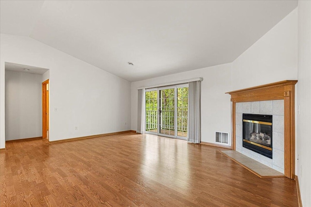 2465 Country Creek Cir Unit 2, West Bend, WI 53095 - unfurnished living room with vaulted ceiling, wood finished floors, a fireplace, and baseboards