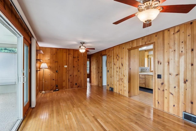 E14485 Baltic Ave, Merrimac, WI 53561 - unfurnished room with ceiling fan, light wood-style flooring, wood walls, and healthy amount of natural light