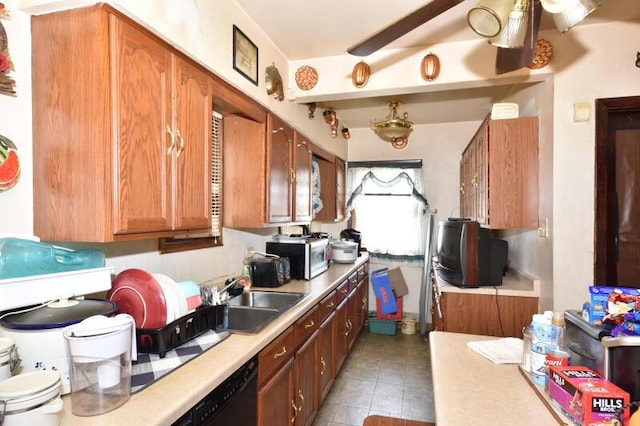 kitchen with a sink, ceiling fan, light countertops, stainless steel microwave, and brown cabinets