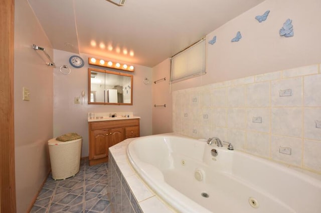 full bath with a jetted tub, vanity, and tile patterned floors