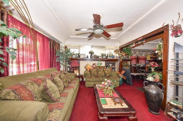 carpeted living area with a ceiling fan