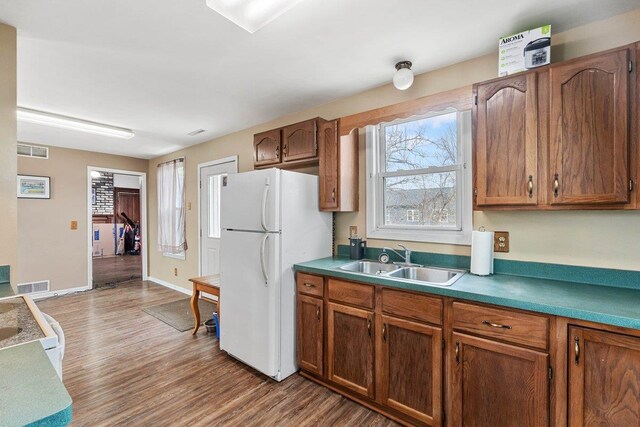 4084 Eagle Mound Pass, Deforest, WI 53532 - kitchen with a sink, freestanding refrigerator, wood finished floors, and brown cabinetry