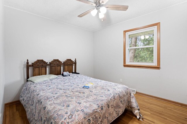 538 124th St, Franksville, WI 53126 - bedroom featuring baseboards, wood finished floors, ceiling fan, and a textured ceiling