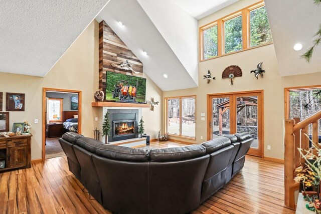 7496 River Rd, Lake Tomahawk, WI 54558 - living area with high vaulted ceiling, a fireplace, hardwood / wood-style flooring, baseboards, and recessed lighting