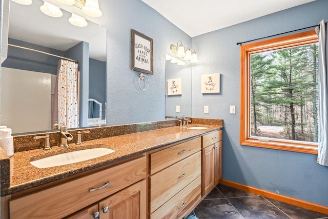 7496 River Rd, Lake Tomahawk, WI 54558 - bathroom featuring tile patterned floors, double vanity, baseboards, a textured wall, and a shower with curtain