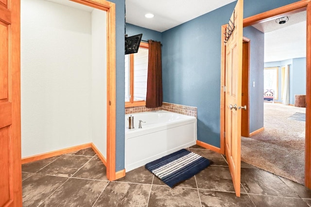 7496 River Rd, Lake Tomahawk, WI 54558 - bathroom with baseboards, a bath, and tile patterned flooring