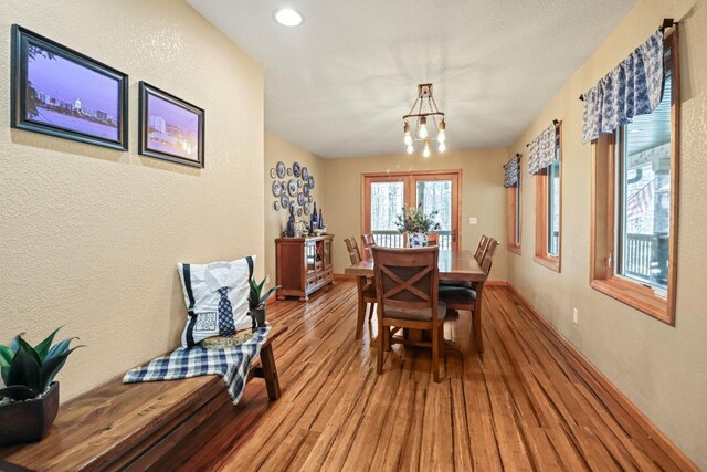 7496 River Rd, Lake Tomahawk, WI 54558 - dining room featuring wood finished floors, a chandelier, a textured wall, baseboards, and recessed lighting