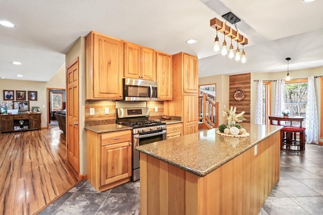 7496 River Rd, Lake Tomahawk, WI 54558 - kitchen with appliances with stainless steel finishes, stone counters, recessed lighting, a kitchen island, and hanging light fixtures
