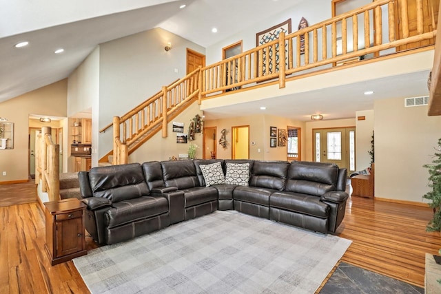7496 River Rd, Lake Tomahawk, WI 54558 - living area with stairway, wood finished floors, baseboards, high vaulted ceiling, and recessed lighting
