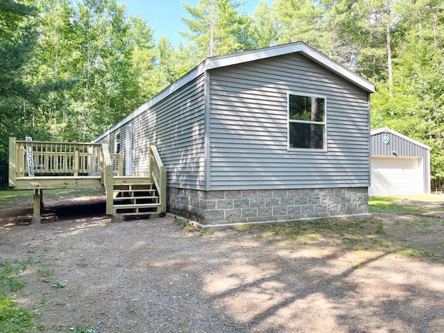 7496 River Rd, Lake Tomahawk, WI 54558 - view of side of property featuring a deck, a detached garage, and an outdoor structure