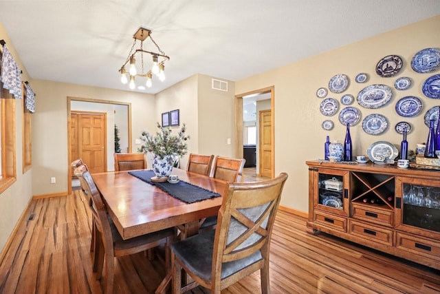 7496 River Rd, Lake Tomahawk, WI 54558 - dining area with light wood-style floors, baseboards, and a chandelier