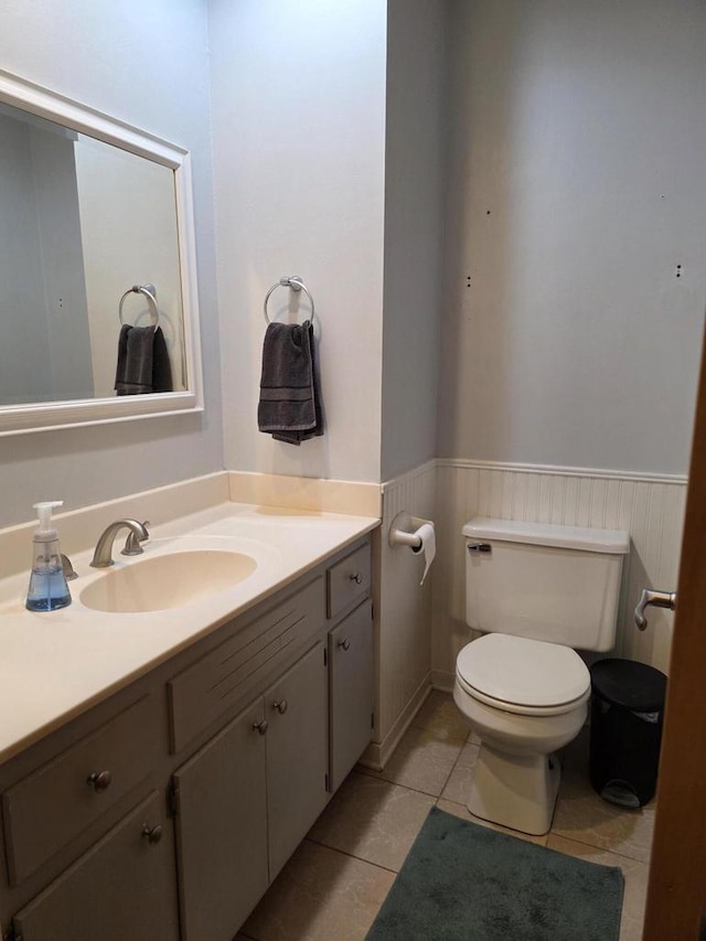 219 Park Ave, Eagle, WI 53119 - half bathroom featuring a wainscoted wall, toilet, vanity, and tile patterned flooring