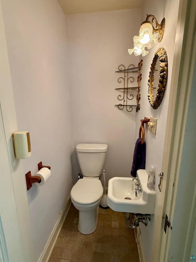514 W 9th Ave, Ashland, WI 54806 - bathroom featuring toilet, a sink, and baseboards