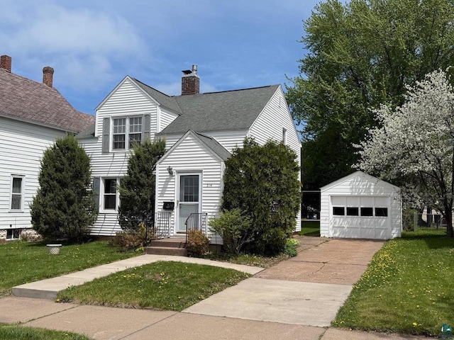 514 W 9th Ave, Ashland, WI 54806 - view of front of property with an outdoor structure, a front lawn, a detached garage, and a chimney
