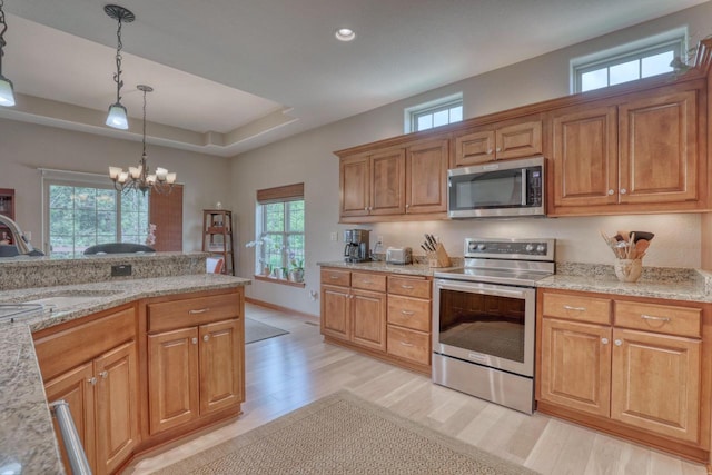 1826 Stonebridge Rd, Waukesha, WI 53188 - kitchen with appliances with stainless steel finishes, a sink, light wood-style flooring, decorative light fixtures, and a chandelier